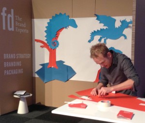 Eine Visualisierung in Collage Technik erregt Aufmerksamkeit auf einer Messe. 