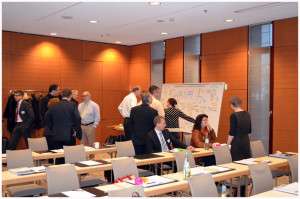 Konferenzraum mit einem Graphic Recorder bei der Arbeit im Hintergrund