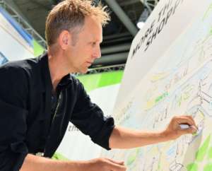 Graphic Recorder legt mit Pastellkreide letzte Hand am Bild