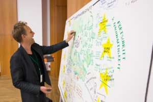 Lachende Graphic Recorder hat spaß bei der Arbeit