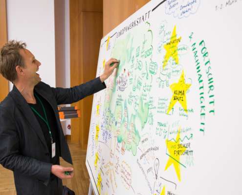 Lachende Graphic Recorder hat spaß bei der Arbeit